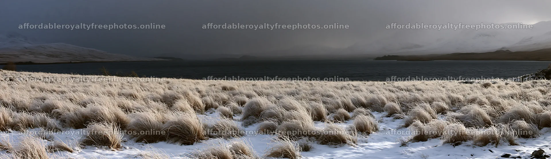 Snowy lakeside meadow with grass and distant mountain – royalty-free photos 14762x4268