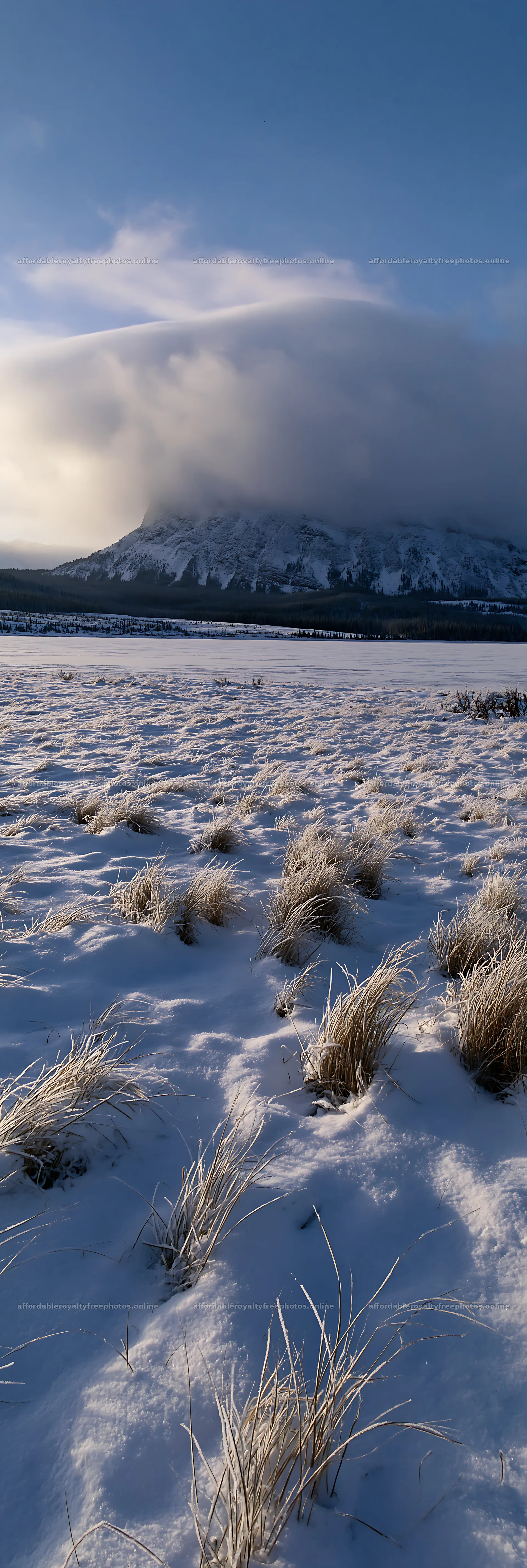 Snowy lakeside meadow with mountains under cloudy sky – royalty-free photos 4602x13690