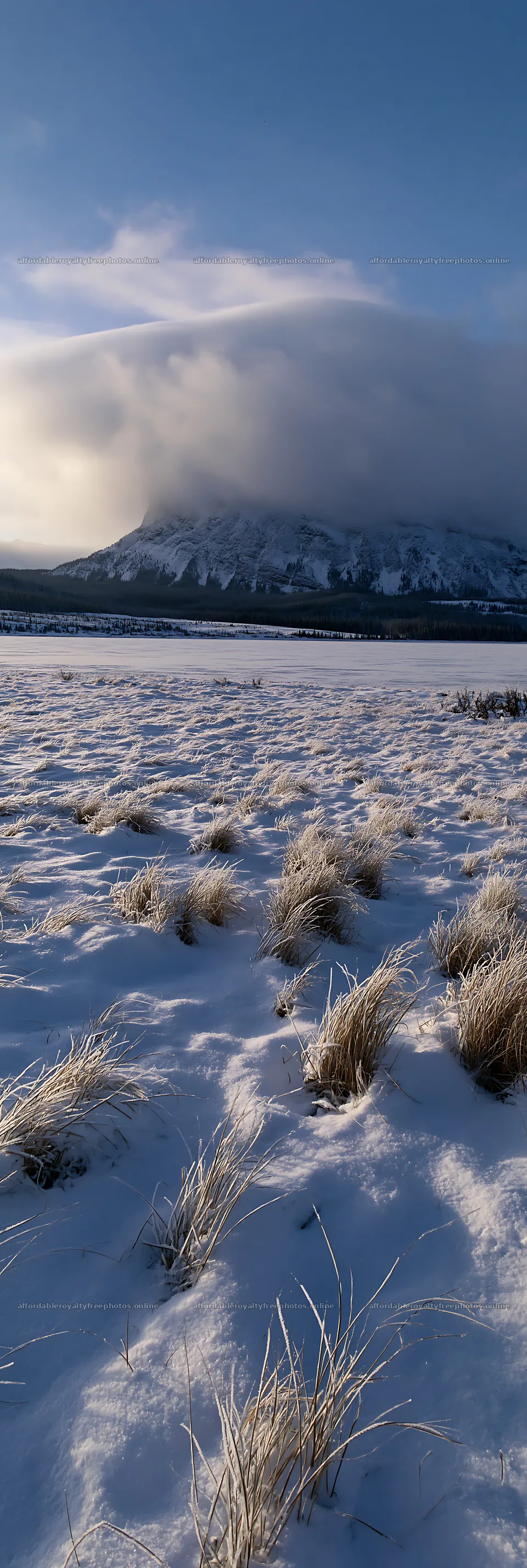 Snowy lakeside meadow with mountains under cloudy sky – royalty-free photos 4602x13690